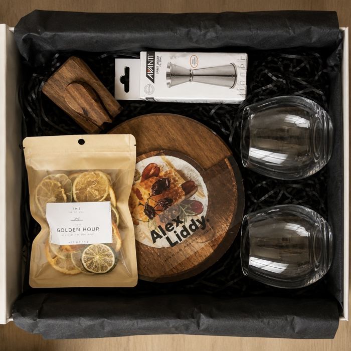 Golden Hour cocktail box with dried citrus, a muddler, jigger, serving board, and stemless glasses