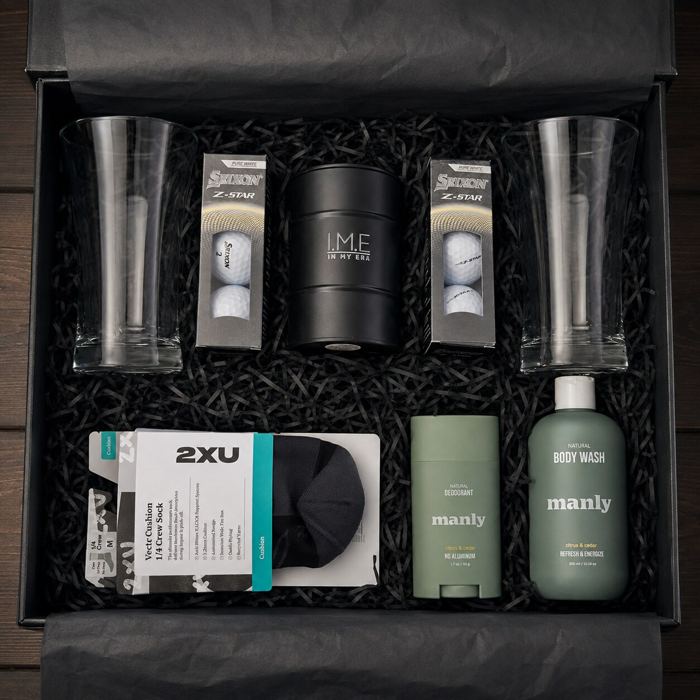 Gift box with beer glasses, golf balls, sports socks, an I.M.E candle, and grooming essentials